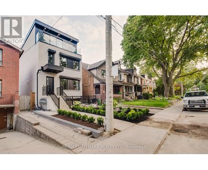 A modern house with a white and black exterior is for sale.