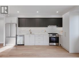 A modern kitchen with white cabinets and a stainless steel refrigerator.
