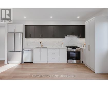 A modern kitchen with white cabinets and a stainless steel refrigerator.