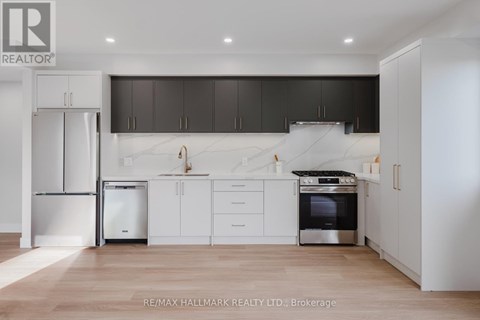 A modern kitchen with white cabinets and a stainless steel refrigerator.