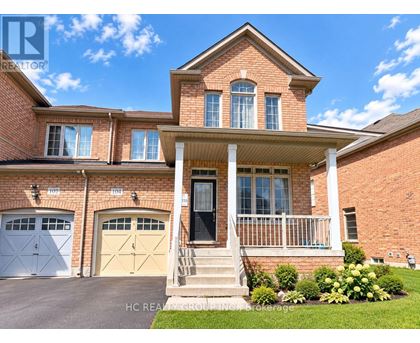 A two-story brick house with a front porch and two garages.