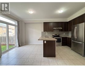 A kitchen with a refrigerator, sink, and oven.