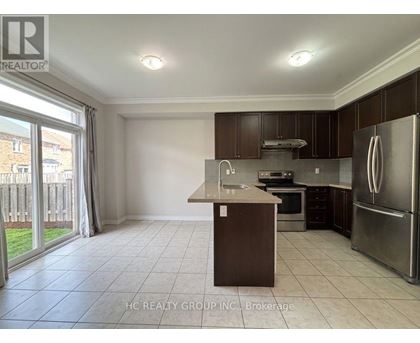 A kitchen with a refrigerator, sink, and oven.