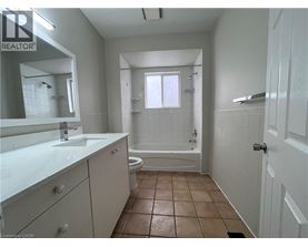 A bathroom with a white counter top and brown floor tiles.
