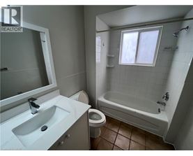 A bathroom with a white sink, toilet, and bathtub.