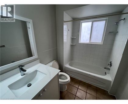 A bathroom with a white sink, toilet, and bathtub.