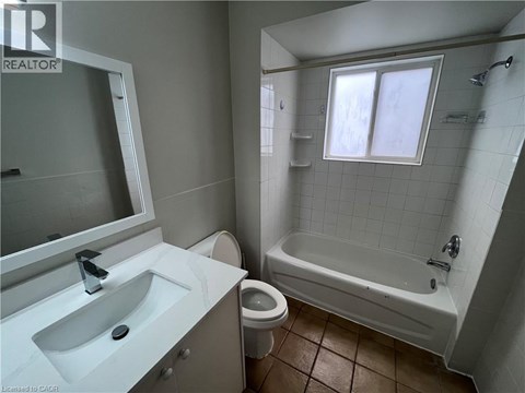 A bathroom with a white sink, toilet, and bathtub.