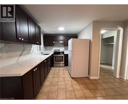 A kitchen with a refrigerator, oven, and cabinets.