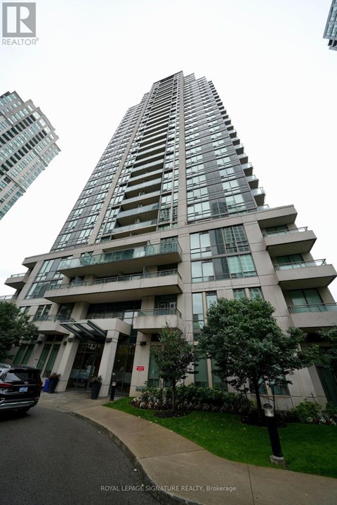 A tall residential building with a car parked in front.