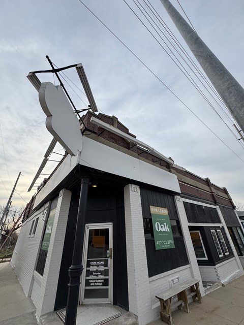 A white and black building with a sign that says Oak.