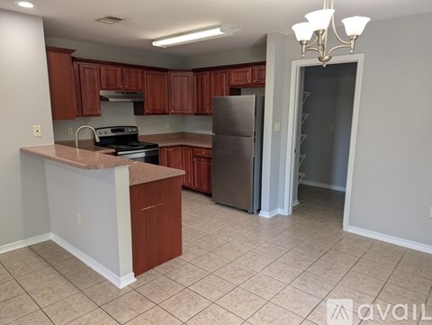 A kitchen with brown cabinets and a granite countertop.