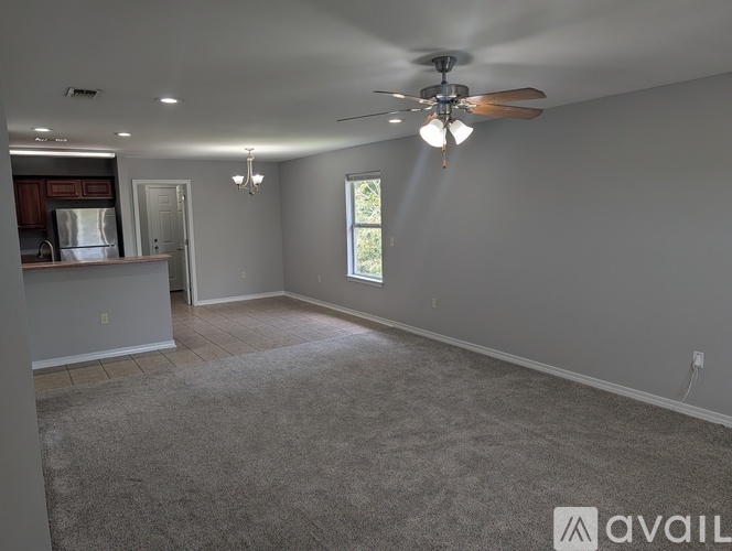A spacious room with a ceiling fan and a window letting in natural light.