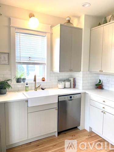 A kitchen with white cabinets and a stainless steel dishwasher.