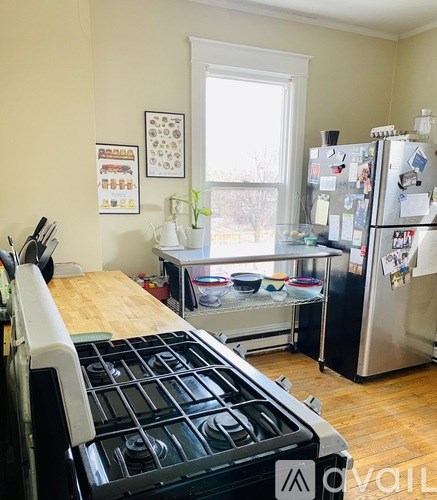 A kitchen with a stove top oven and a refrigerator with magnets and notes on it.