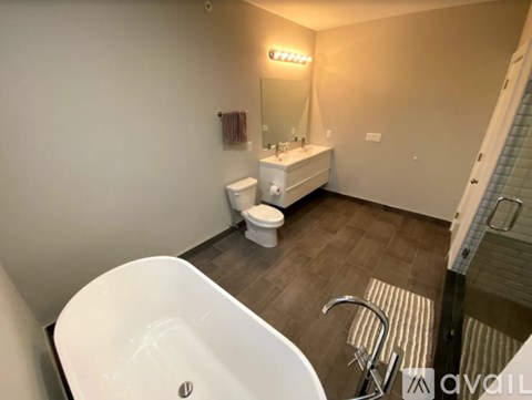 A bathroom with a white tub and toilet.