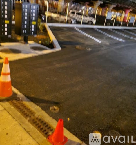 A street with orange cones and a white car in the background.