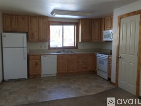 A kitchen with wooden cabinets and a white refrigerator.