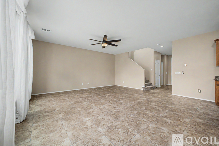 A spacious room with a ceiling fan and a marble floor.