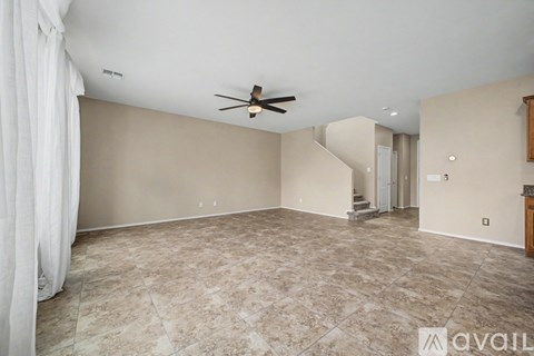 A spacious room with a ceiling fan and a marble floor.