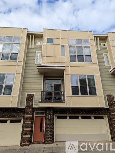 A building with a balcony and a red door is for sale.