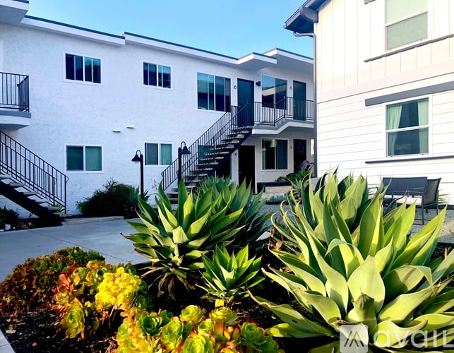 A white building with a balcony and a staircase.