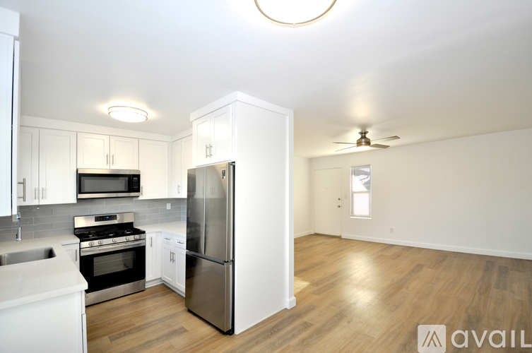 A kitchen with white cabinets and a stainless steel refrigerator.