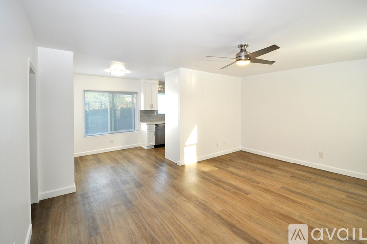 A room with a ceiling fan and wooden flooring.