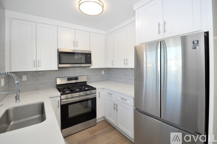 A kitchen with white cabinets and stainless steel appliances.