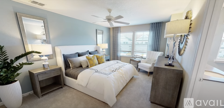 A bedroom with a large bed and a ceiling fan.