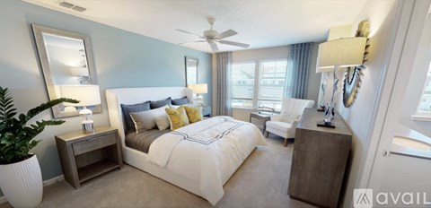 A bedroom with a large bed and a ceiling fan.