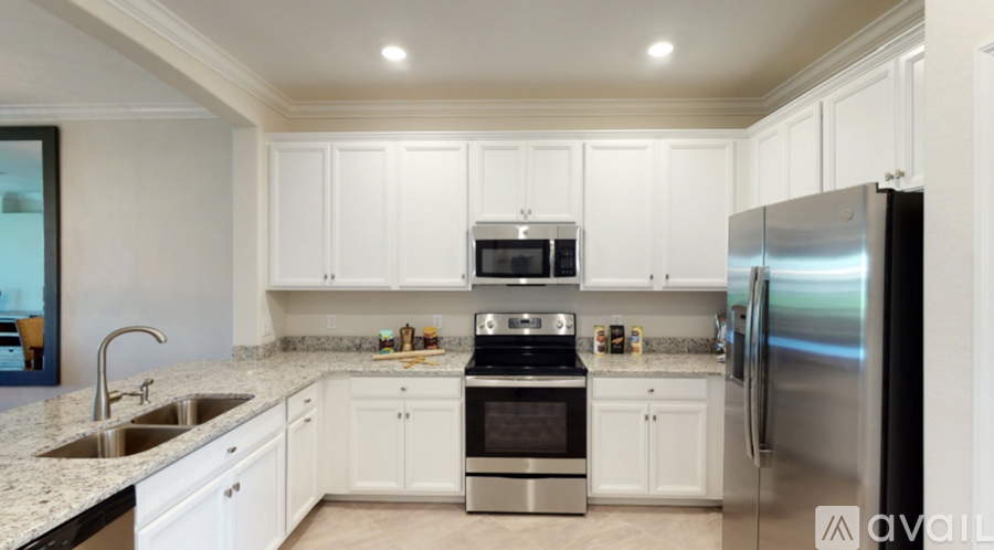 A kitchen with white cabinets and stainless steel appliances.