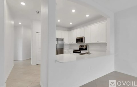 A kitchen with white cabinets and stainless steel appliances.