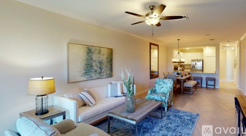 A living room with a white couch, a coffee table, and a painting on the wall.