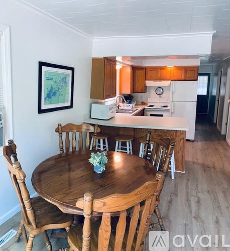 A kitchen with a table and chairs in the foreground.