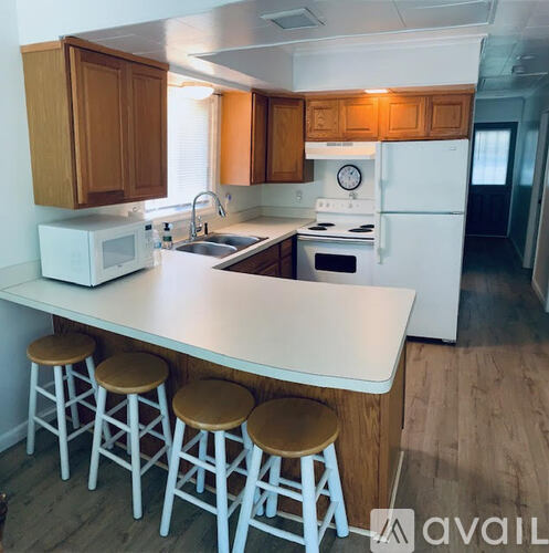 A kitchen with white appliances and wooden cabinets.