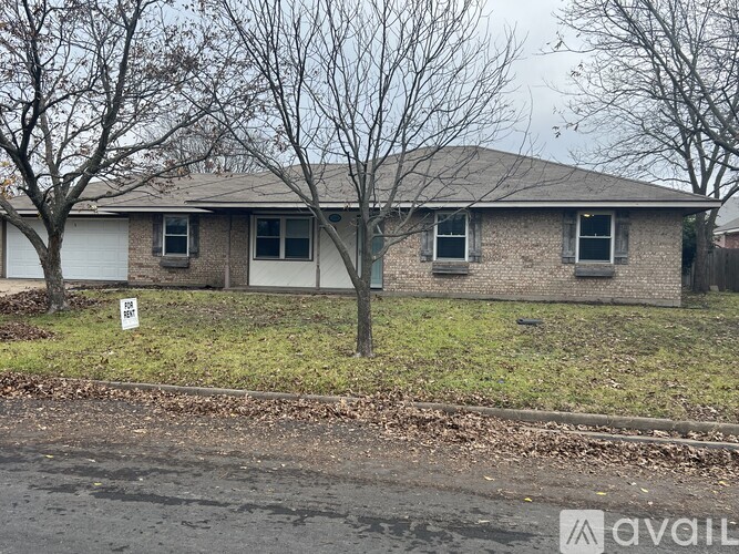 A house with a sign that says "For Sale" in front of it.