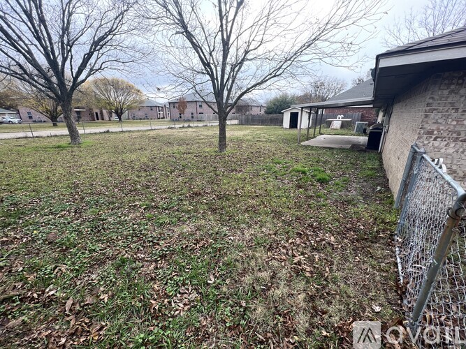 A backyard with a fence and trees.