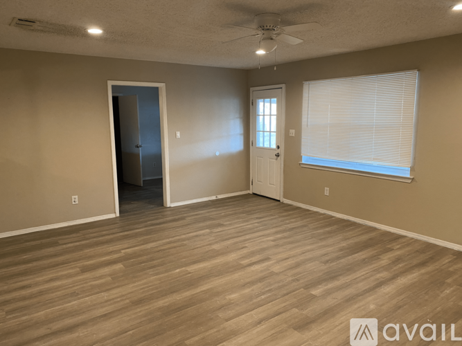 A room with a ceiling fan and two doors.