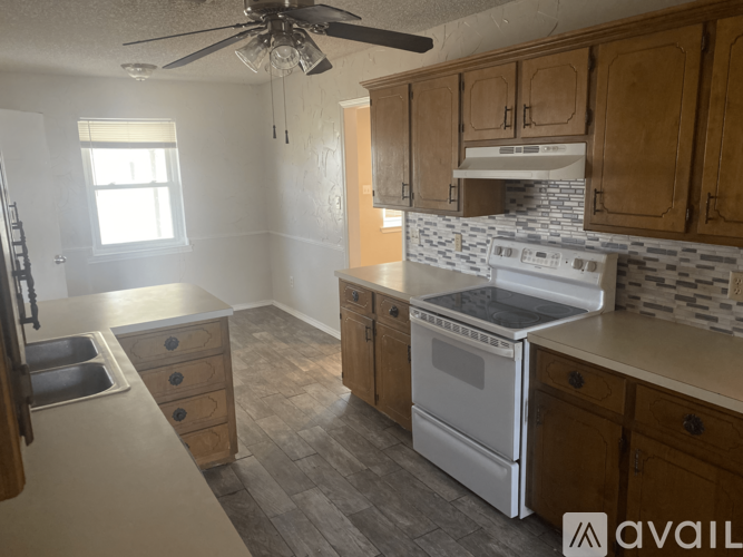 A kitchen with wooden cabinets and a white stove top oven.