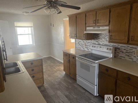 A kitchen with wooden cabinets and a white stove top oven.