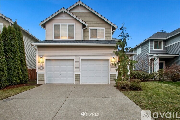 A two-story house with a garage is available for sale.