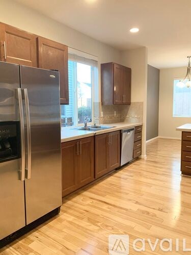 A kitchen with wooden cabinets and a stainless steel refrigerator.