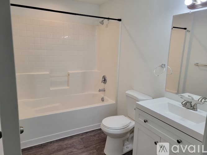 A white bathroom with a toilet, sink, and bathtub.