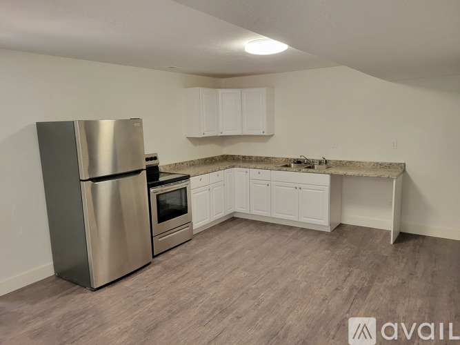 A kitchen with a stainless steel refrigerator, oven, and cabinets.