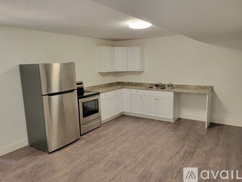 A kitchen with a stainless steel refrigerator, oven, and cabinets.