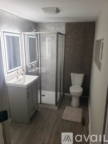 A bathroom with a toilet, sink, and shower.