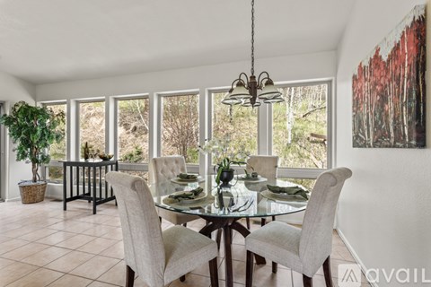 A dining room with a glass table and chairs.