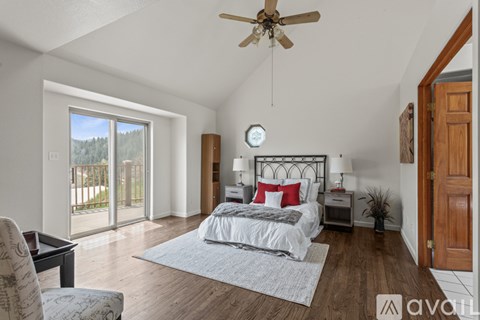 A bedroom with a bed, nightstand, and sliding glass doors.