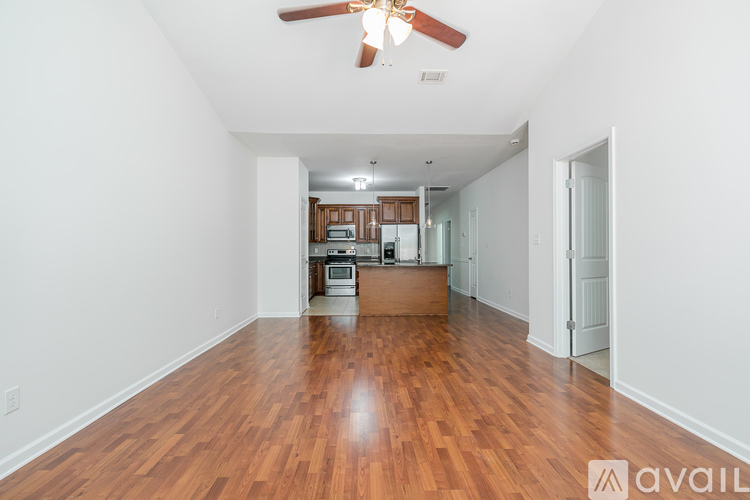 A spacious room with wooden floors and a ceiling fan.