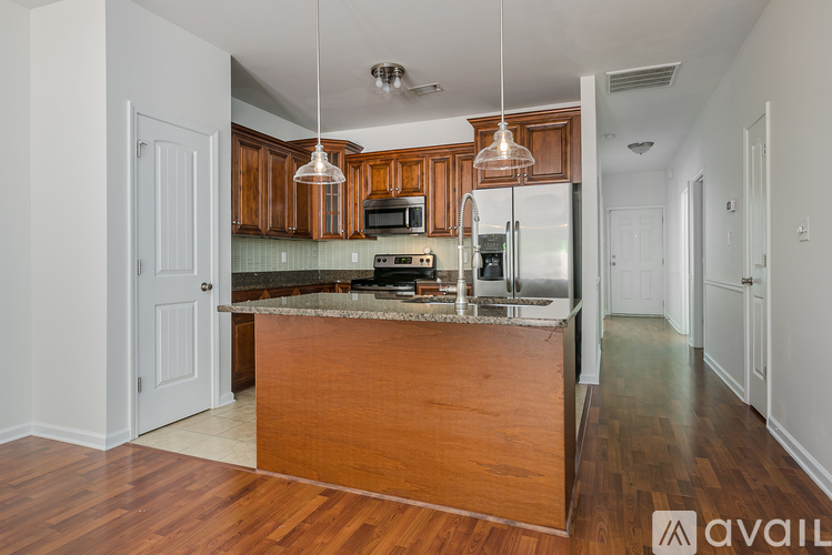 A kitchen with wooden cabinets and a marble countertop.
